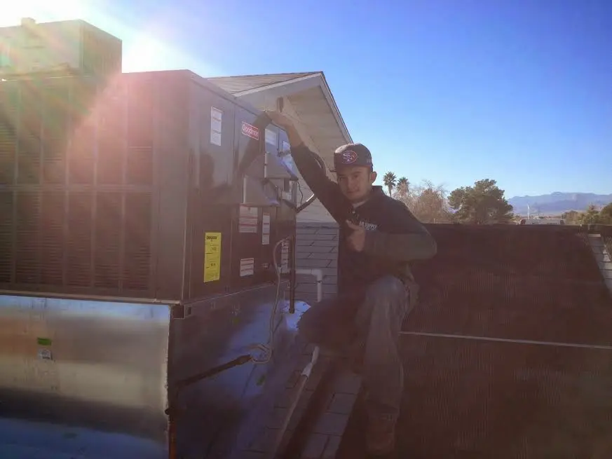 HVAC technician performing AC Tune-Up on a rooftop unit in Highland City
